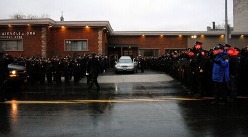 22日下午数百名警员挺立雨中，敬礼迎接战友刘文健遗体。（美国《侨报》/崔国萁