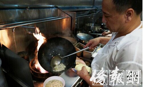 一家陕西餐馆的厨师郝志德把刚刚烧好的羊肉泡馍盛入碗内。（美国《侨报》/邱晨