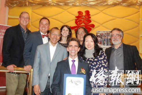 雷诺（前中）手捧丁右立颁发的贺状，与华协中心行政主任方小龙（后右1）及多位加州和旧金山民选官员合影（侨报记者吴卓明摄）